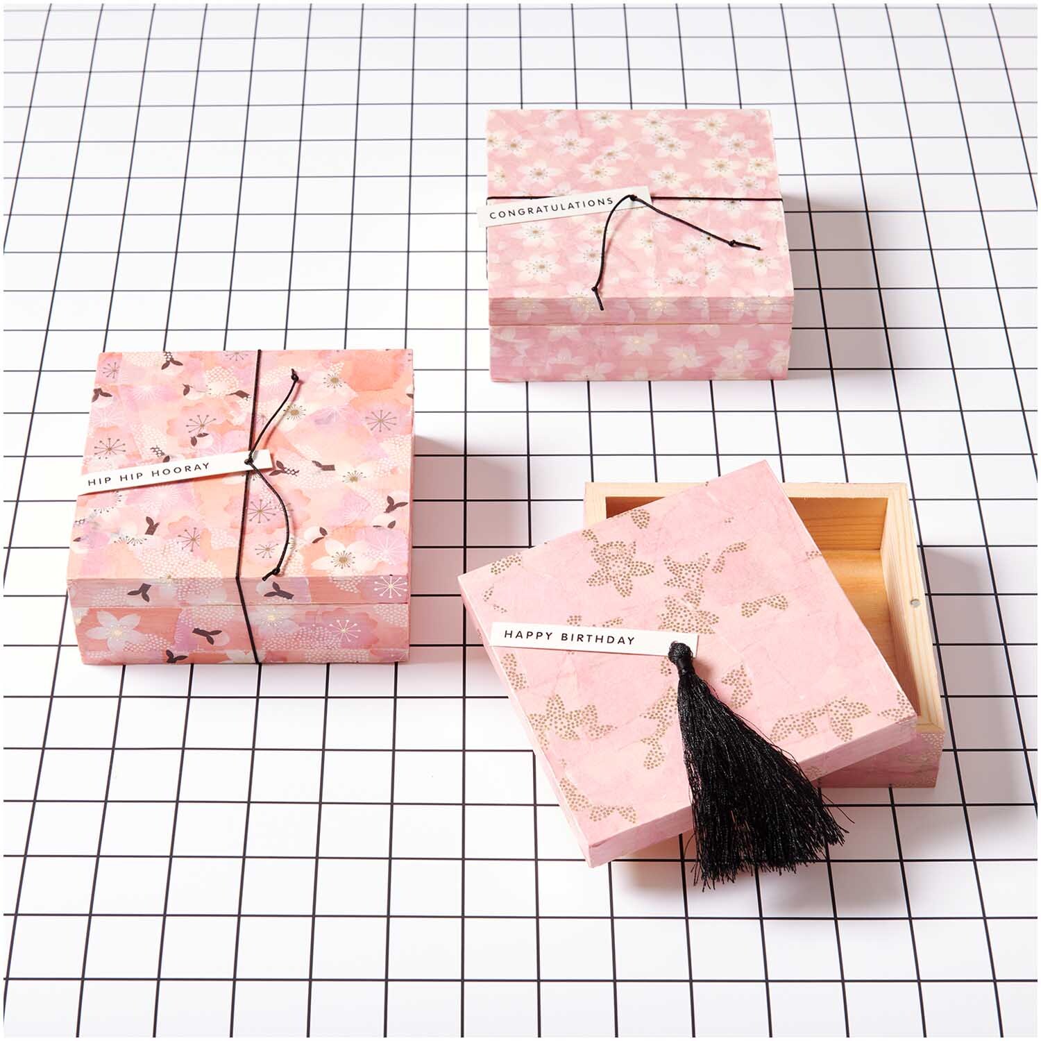 Paper Poetry Paper Patch Papier zeigt goldene Kirschblüten auf Geschenkboxen in Rosa, ideal für kreative Verpackungen.