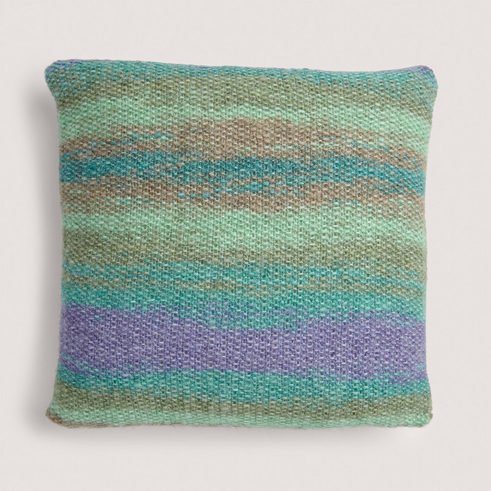 Blaues Kissen auf grauem Hintergrund – zum Strickset
