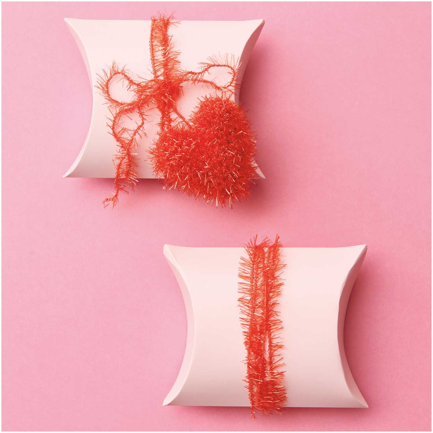 Creative Bubble Set Good Luck! Zwei weiße Geschenkboxen mit rotem Garn auf rosa Hintergrund. Ideal für kreative Projekte von Rico Design.