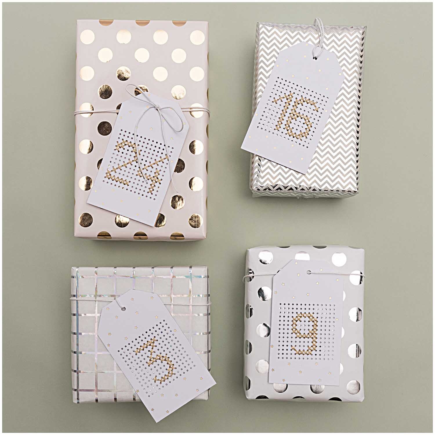 Paper Poetry Geschenkpapier mit silbernen Punkten, dekorativ verpackte Geschenke mit nummerierten Anhängern. Ideal für festliche Anlässe.