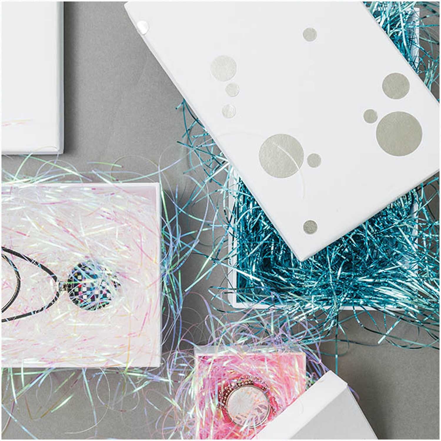 Paper Poetry Füllmaterial Flitter 20g in Geschenkboxen mit glänzendem, weißem Füllmaterial von Rico Design. Ideal für kreative Verpackungen.