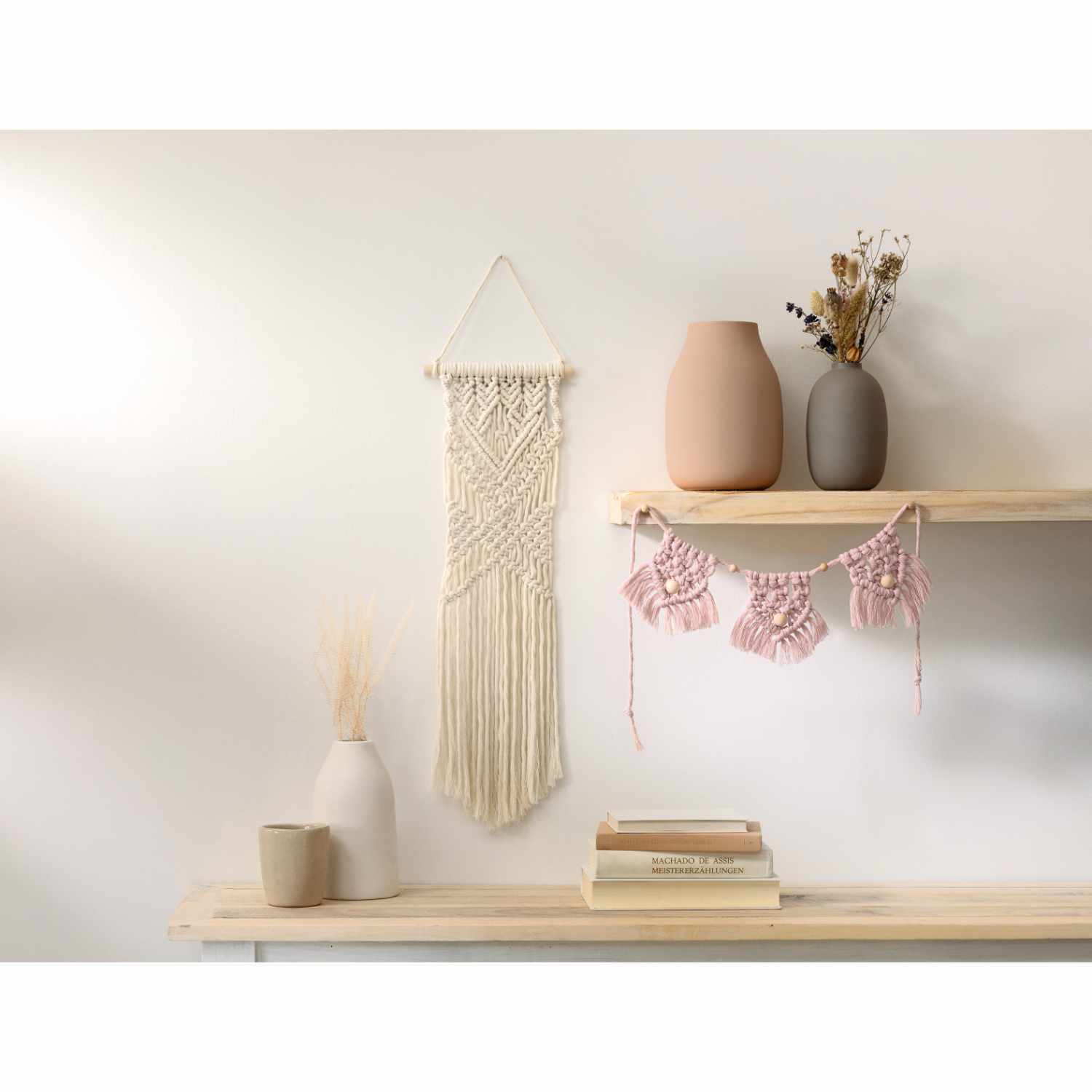Makramee-Set Boho: Wanddekoration mit beige Makramee, rosa Girlande und Vasen auf Holzregal. Ideal für stilvolle Wohnräume.