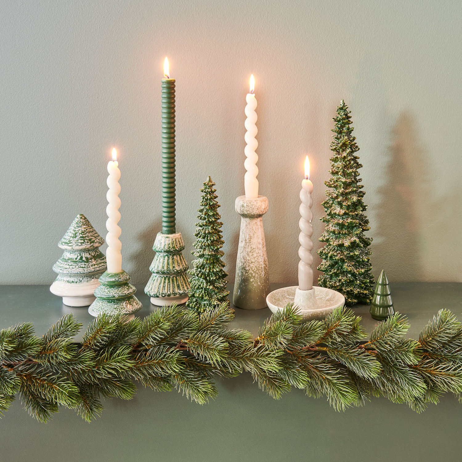 Porzellan Tannenbaum Grün-Weiß, dekoriert mit grünen und weißen Kerzenhaltern und Tannenbäumen auf einem Tisch.