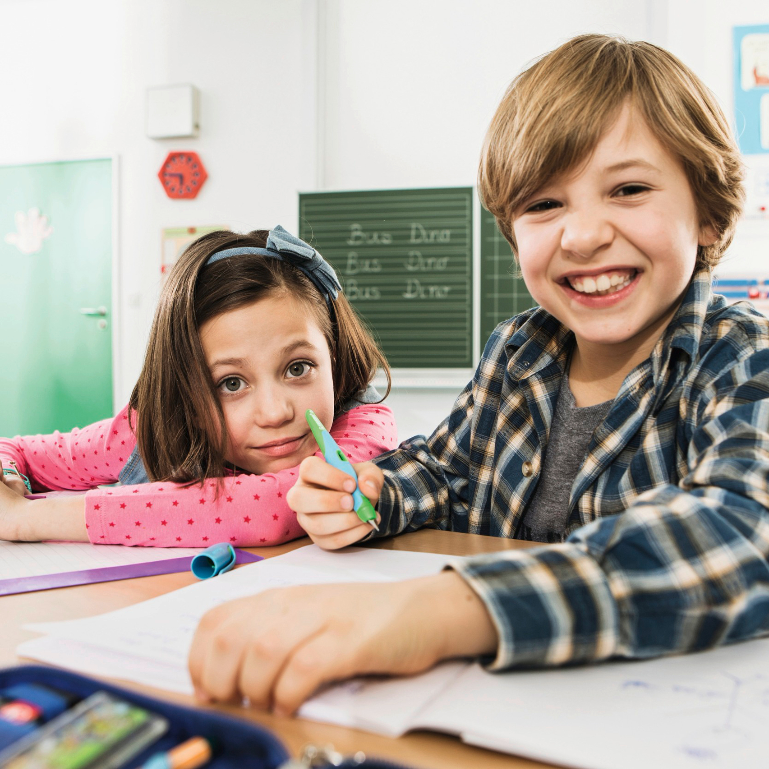 Easybird Patronenfüller für Rechtshänder: Zwei Kinder lachen beim Schreiben in einem Klassenzimmer.