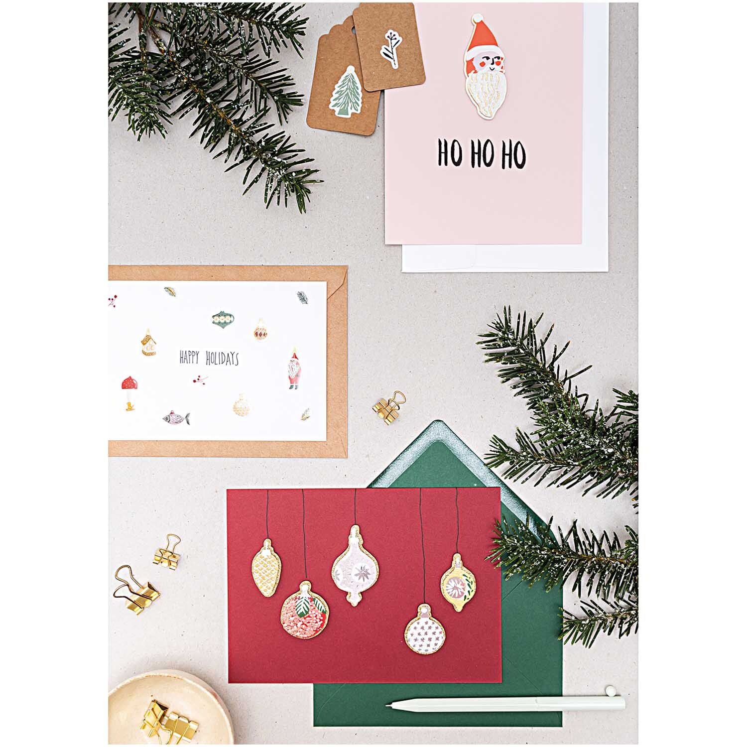 Paper Poetry Gelsticker Nostalgic Christmas classic von Rico Design zeigt festliche Karten mit Weihnachtsmotiven und Tannenzweigen auf einem Tisch.