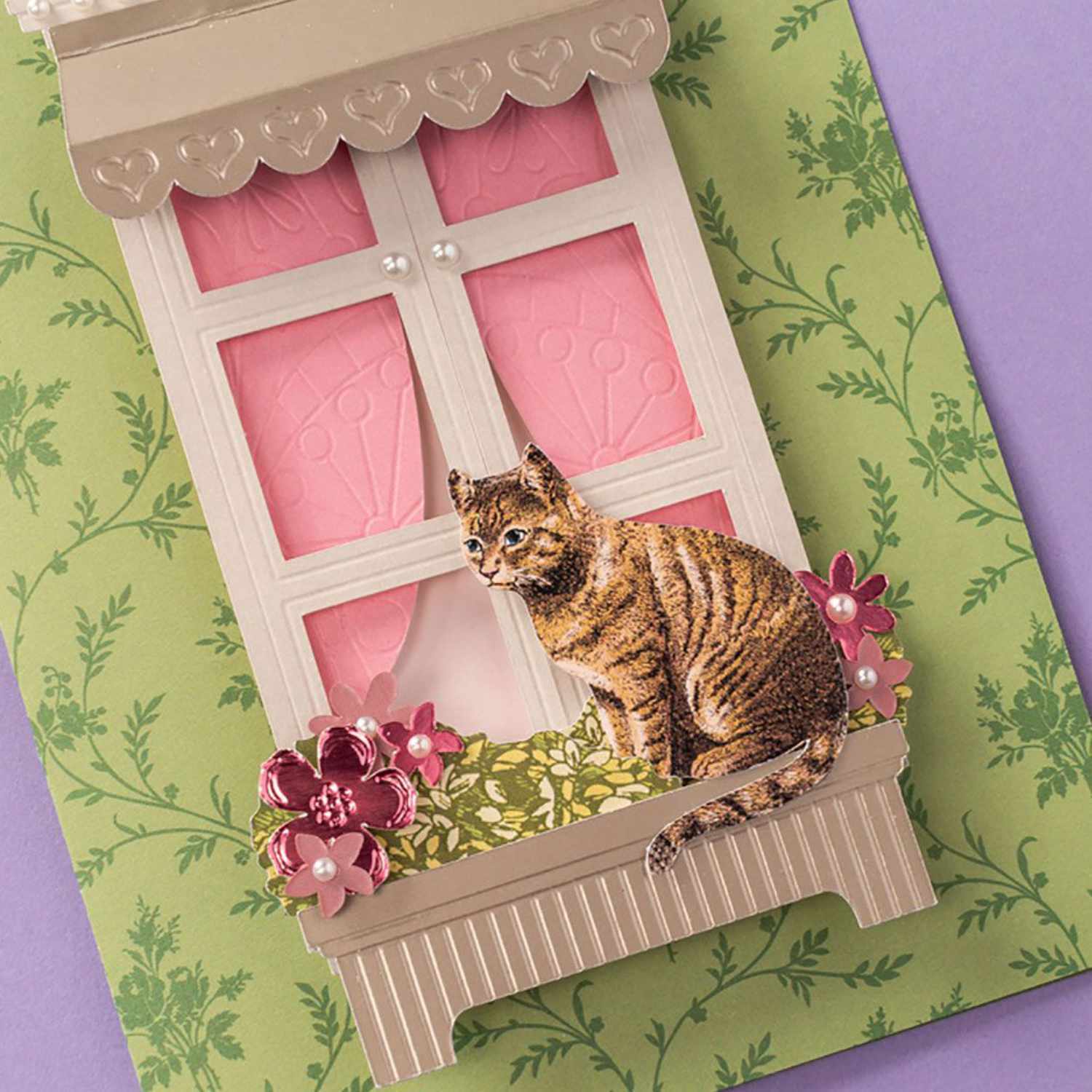 Maker Fine Debossing Tip 21 Prägeklinge: Ein Fenster mit rosa Vorhängen, verziert mit Blumen und einer Katze, auf grünem Hintergrund.