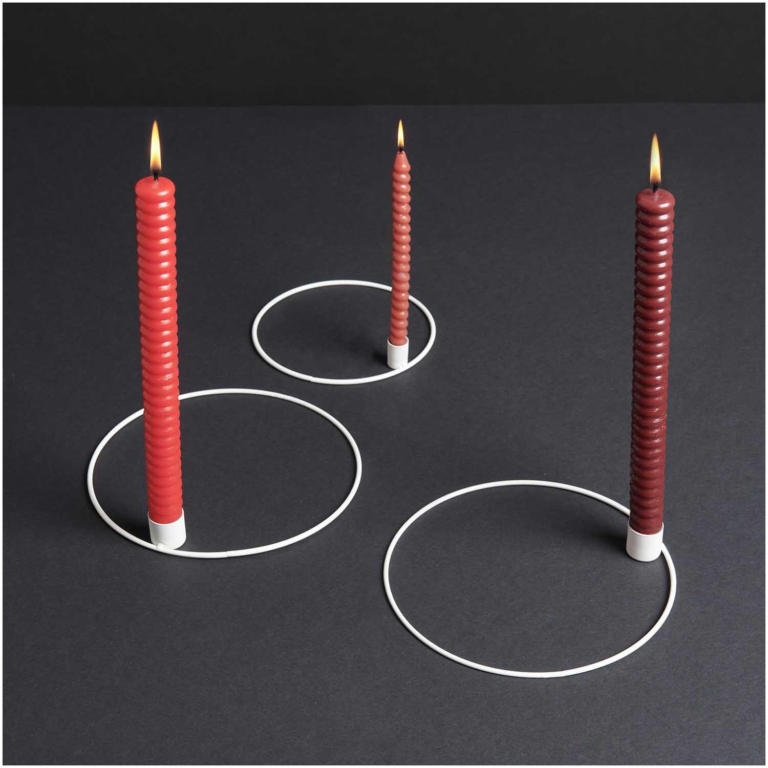 Metallring mit Kerzenhalter Ø 20cm: Drei rote Kerzen in weißen, matten Haltern auf dunklem Hintergrund.