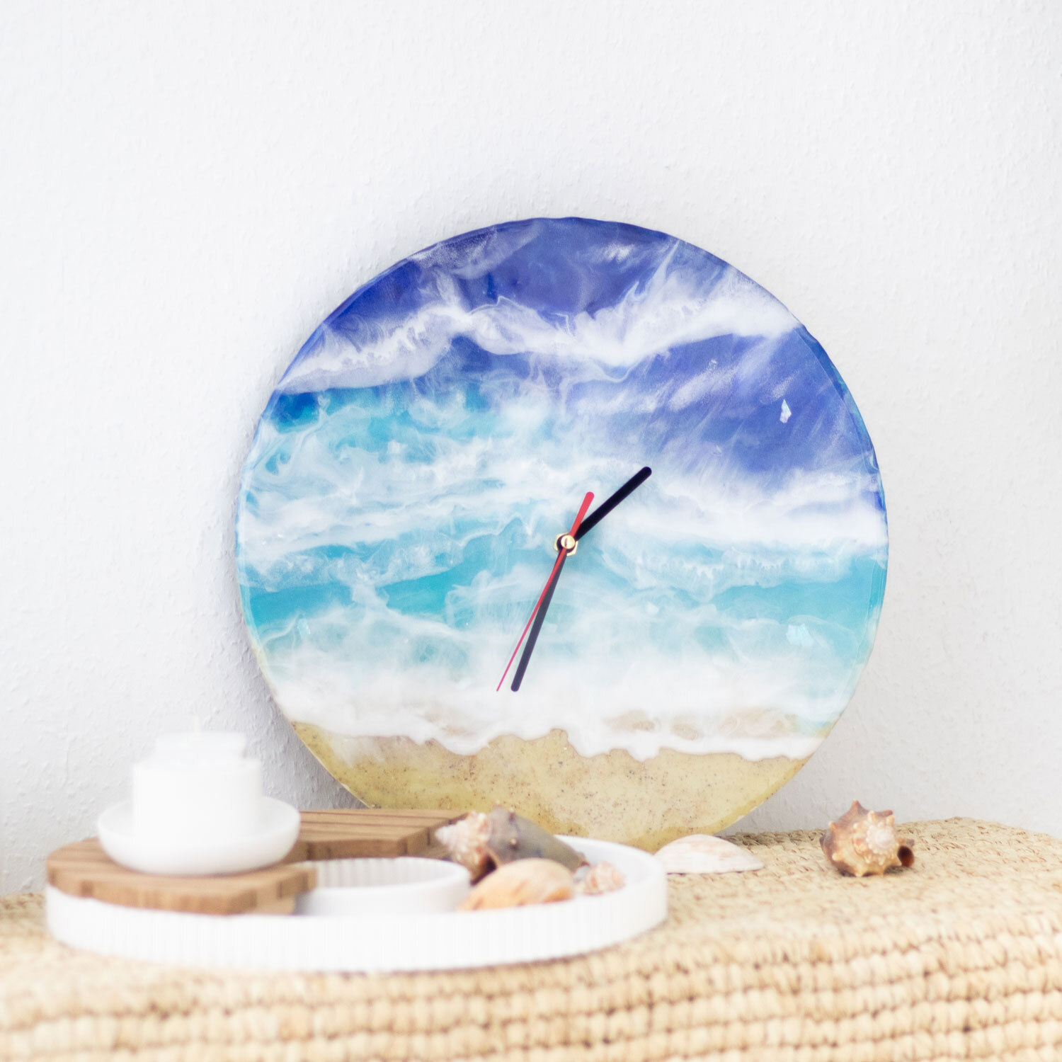 Inspiration Resin Wanduhr zeigt ein Ozeanmotiv mit blauen und weißen Wellen, dekorativ platziert.