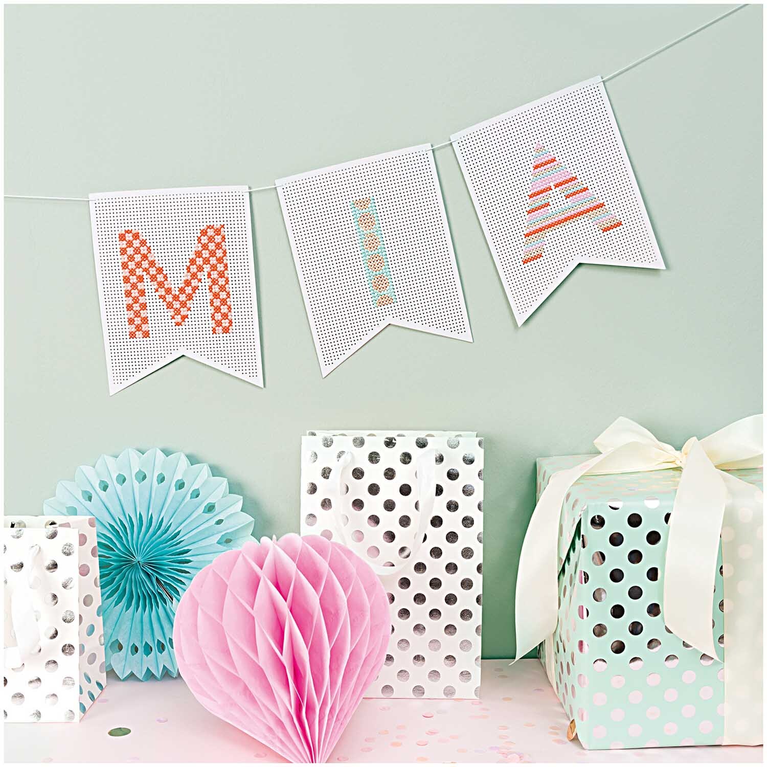 Paper Poetry Stickkarton Girlande mit Fähnchen und Buchstaben "MIA", dekoriert mit Geschenken und Papierornamenten. Ideal für kreative Dekorationen.