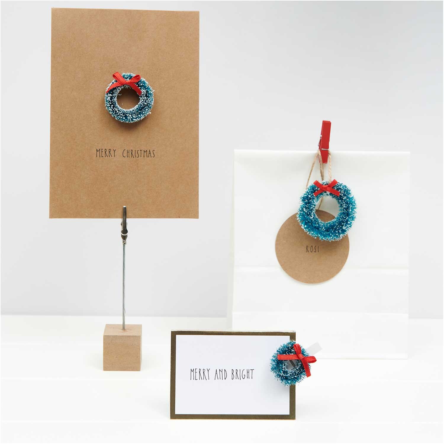 Hänger Weihnachtskranz grün 50x50mm 3 Stück von Rico Design, dekoriert mit roten Schleifen, präsentiert auf Karten und Geschenken.