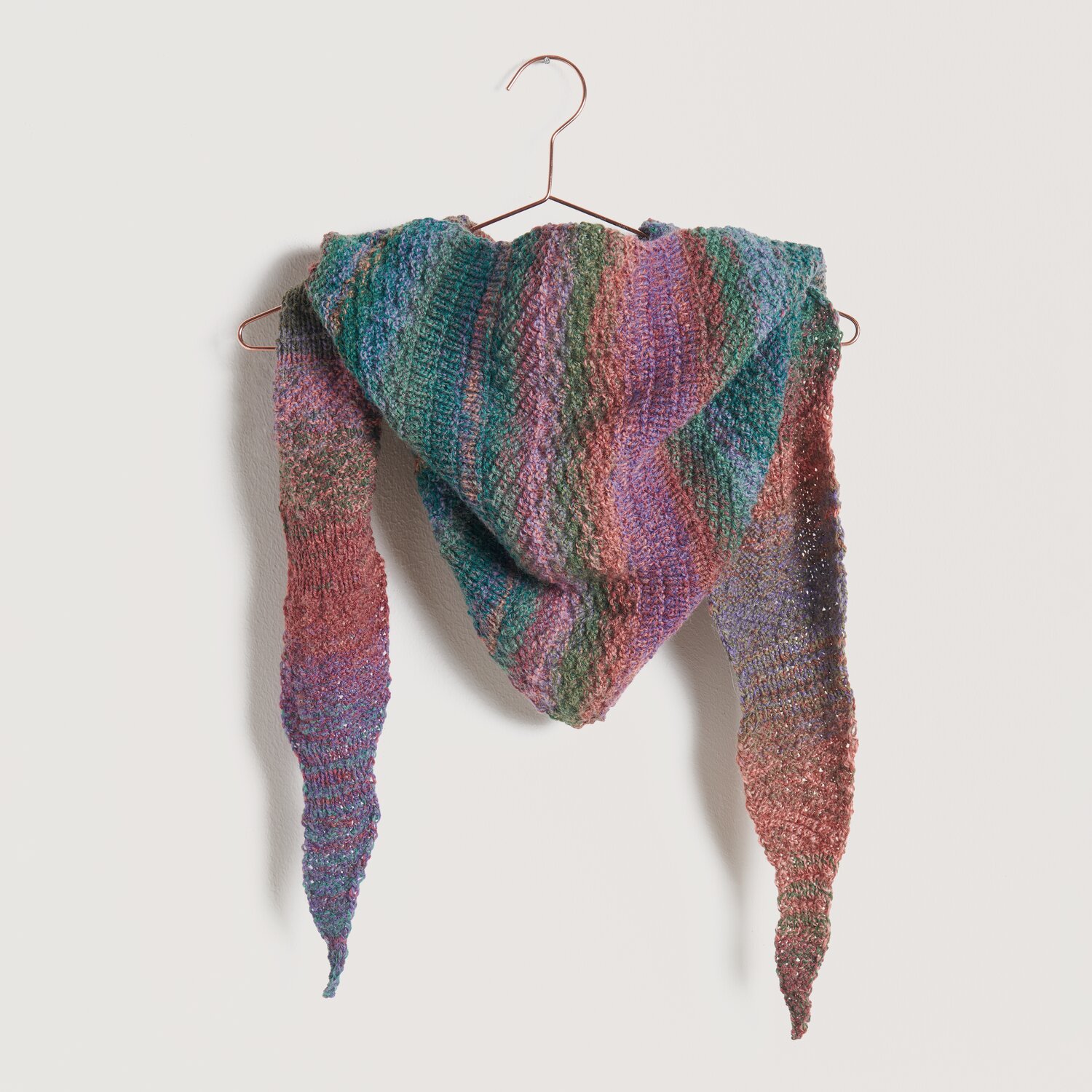 Strickset Tuch Modell 20b aus Die Neue Masche No. 10: Ein buntes, gestricktes Tuch auf einem Kleiderbügel.