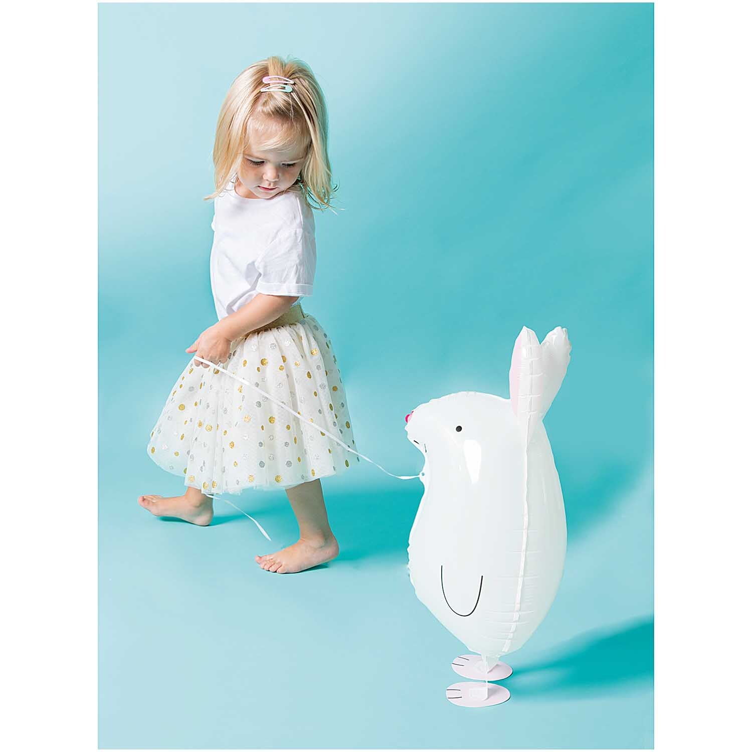 Folienballon Hase 23x60cm: Weißer Ballon in Hasenform von Rico Design, gehalten von einem Kind.