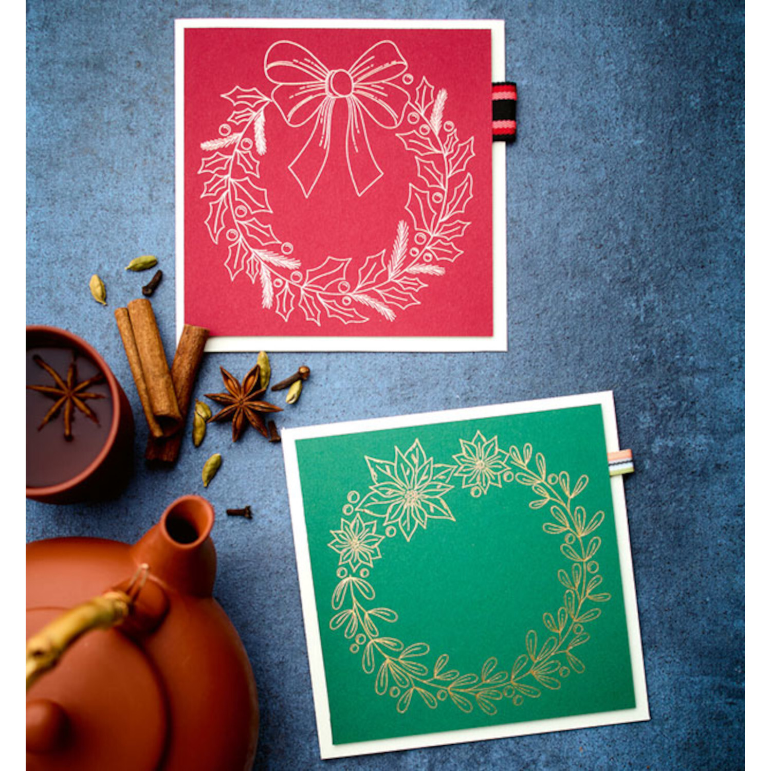 Großes Weihnachts-Plotterbuch: Zwei festliche Karten mit Kranzmotiven in Rot und Grün auf blauem Hintergrund.