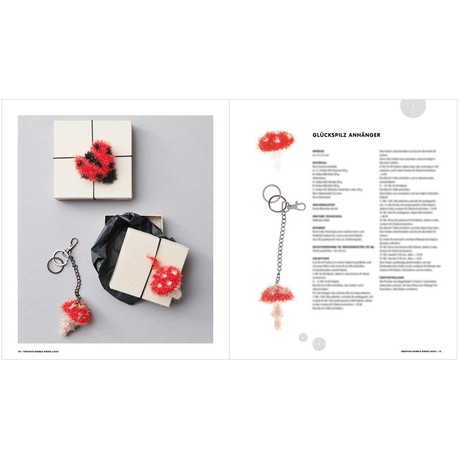 Creative Bubble - Good Luck! Schlüsselanhänger in Rot und Weiß, dekorativ auf Geschenkboxen arrangiert. Ideal für kreative DIY-Projekte.