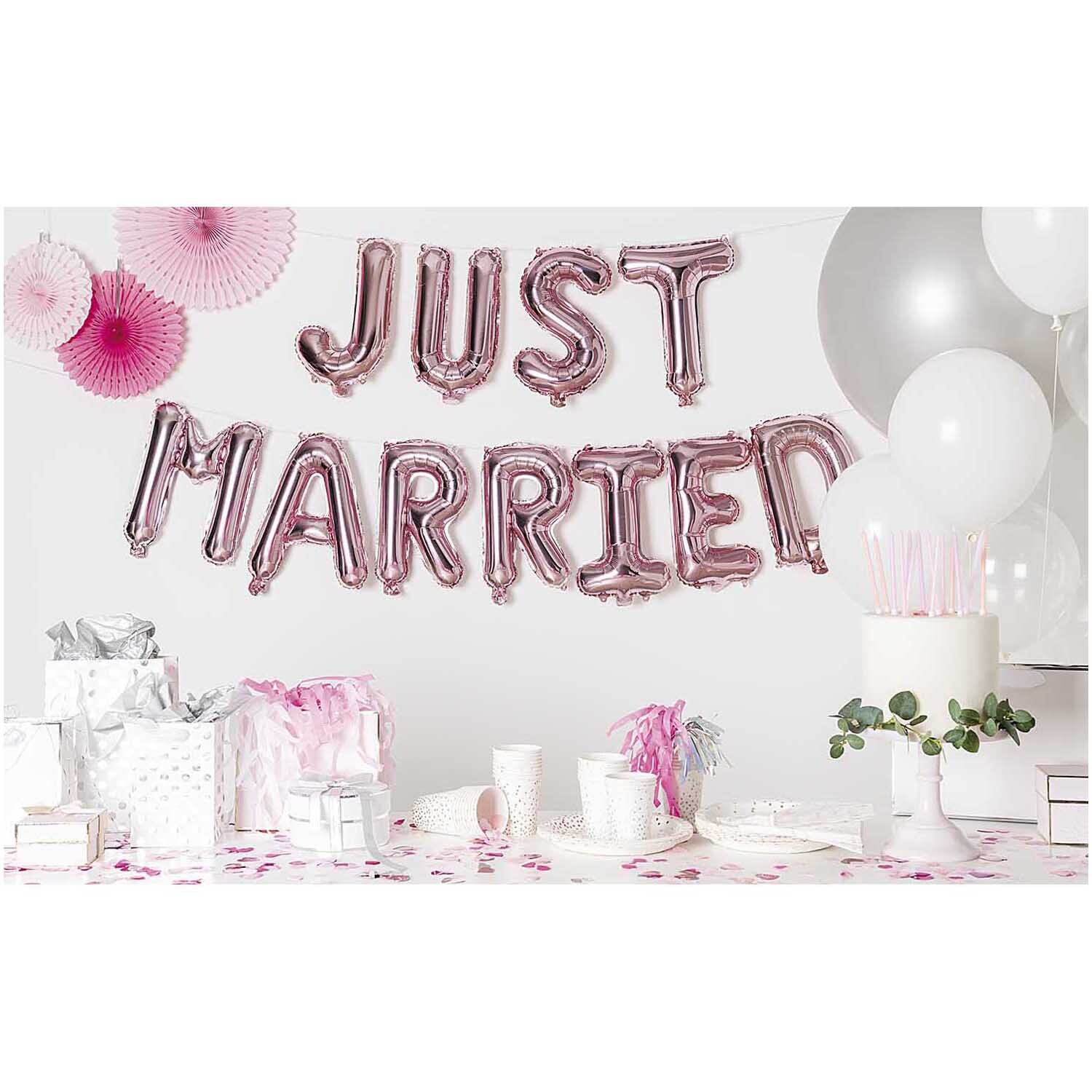 Folienballon-Set Just married rosa: Rosa Ballons mit Schriftzug, umgeben von Partydekorationen.
