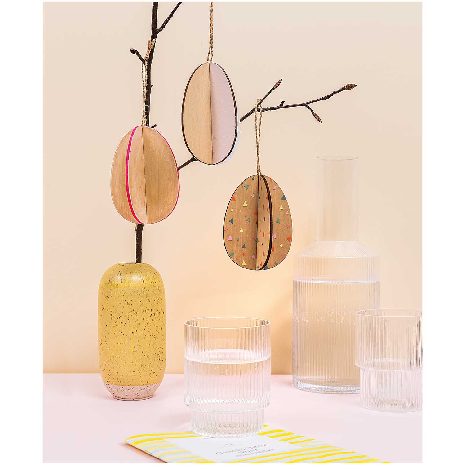 Steckeier 5x7cm 3 Stück: Drei braune Deko-Eier von Rico Design hängen an einem Ast in einer gelben Vase.