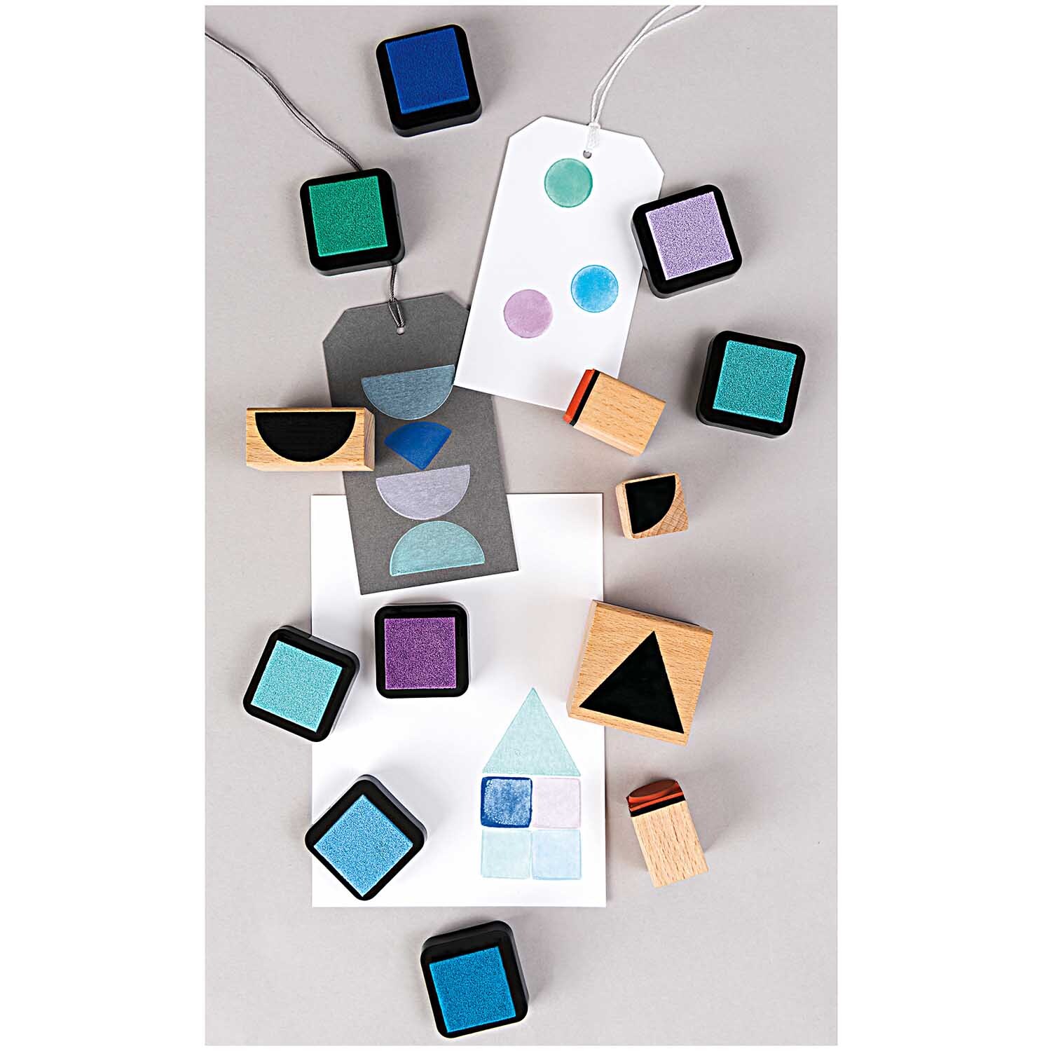 Paper Poetry Stempelset geometrische Symbole eckig von Rico Design, 7-teilig. Enthält bunte Stempelkissen und geometrische Holzstempel auf grauem Hintergrund.