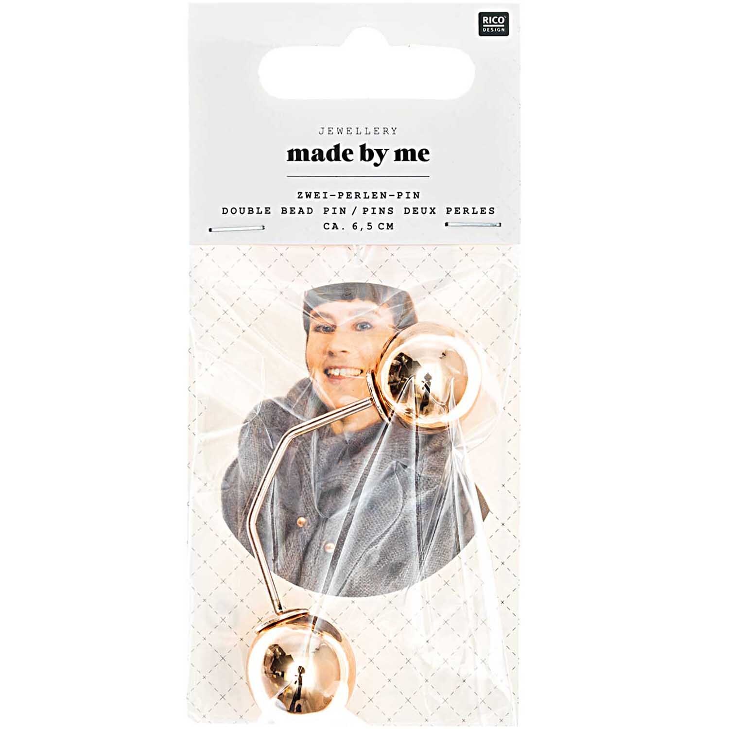 Zwei-Perlen-Pin in Roségold von Rico Design, 65mm lang, auf einer Verpackung mit lächelnder Person.