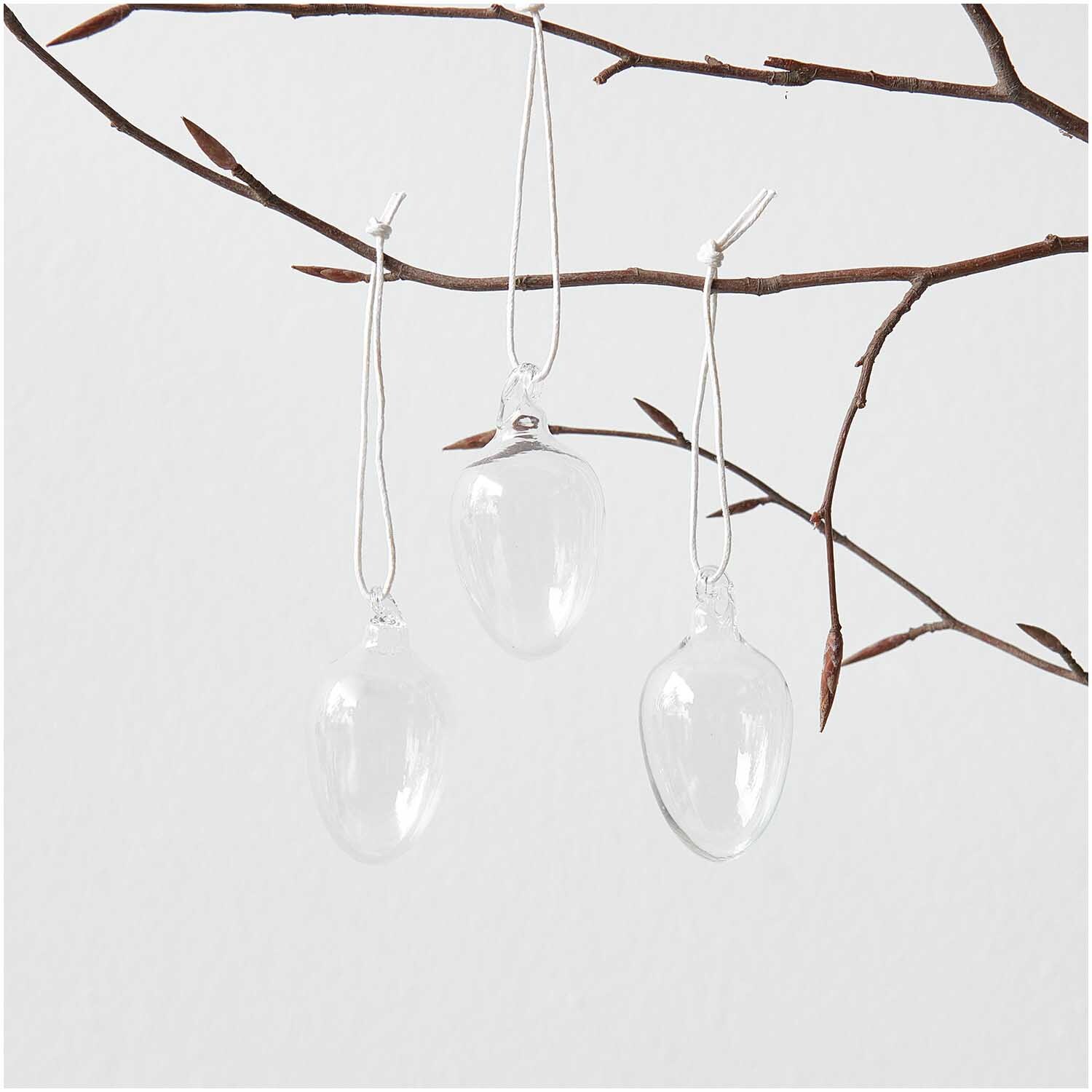 Glas Eier transparent 4 Stück Ø 3cm von Rico Design hängen an einem Ast, ideal für Dekoration.