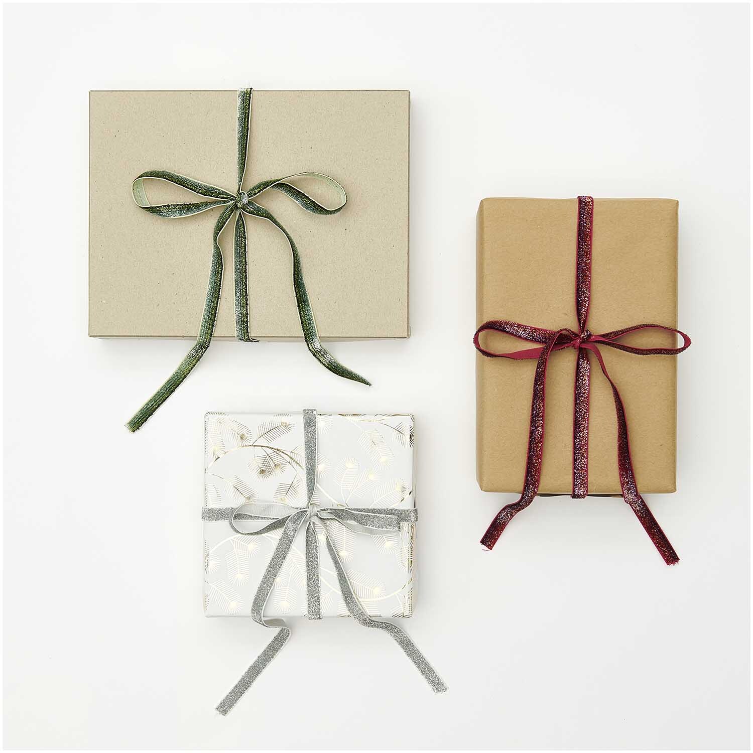 Paper Poetry Glitzerband 10mm 3m von Rico Design verziert drei Geschenke mit funkelndem Glanz.
