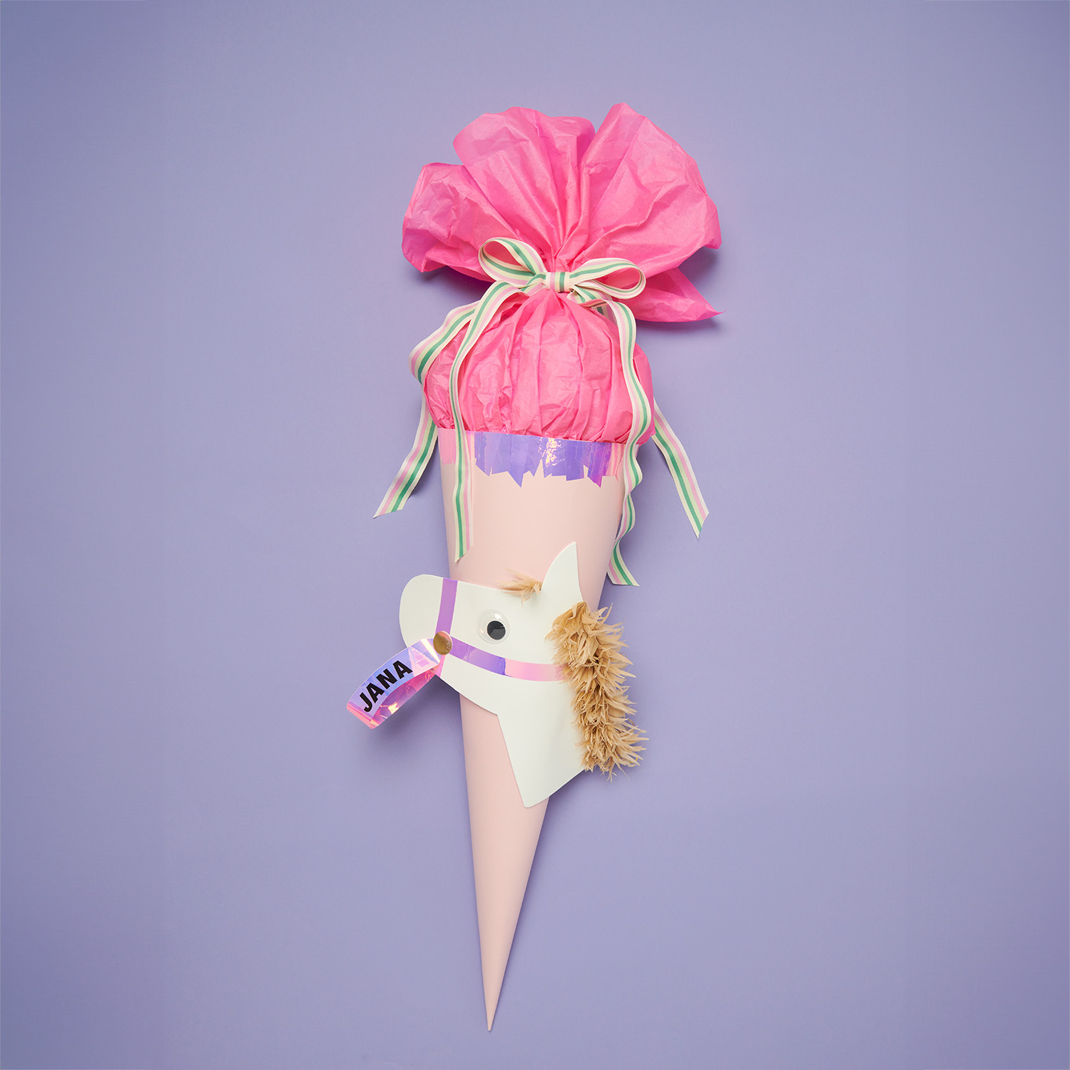 Bastelset Schultüte Pferd von Rico Design in Rosa. Das Bild zeigt eine dekorative Schultüte mit Pferdemotiv, verziert mit bunten Bändern und einem pinken Tüllabschluss.