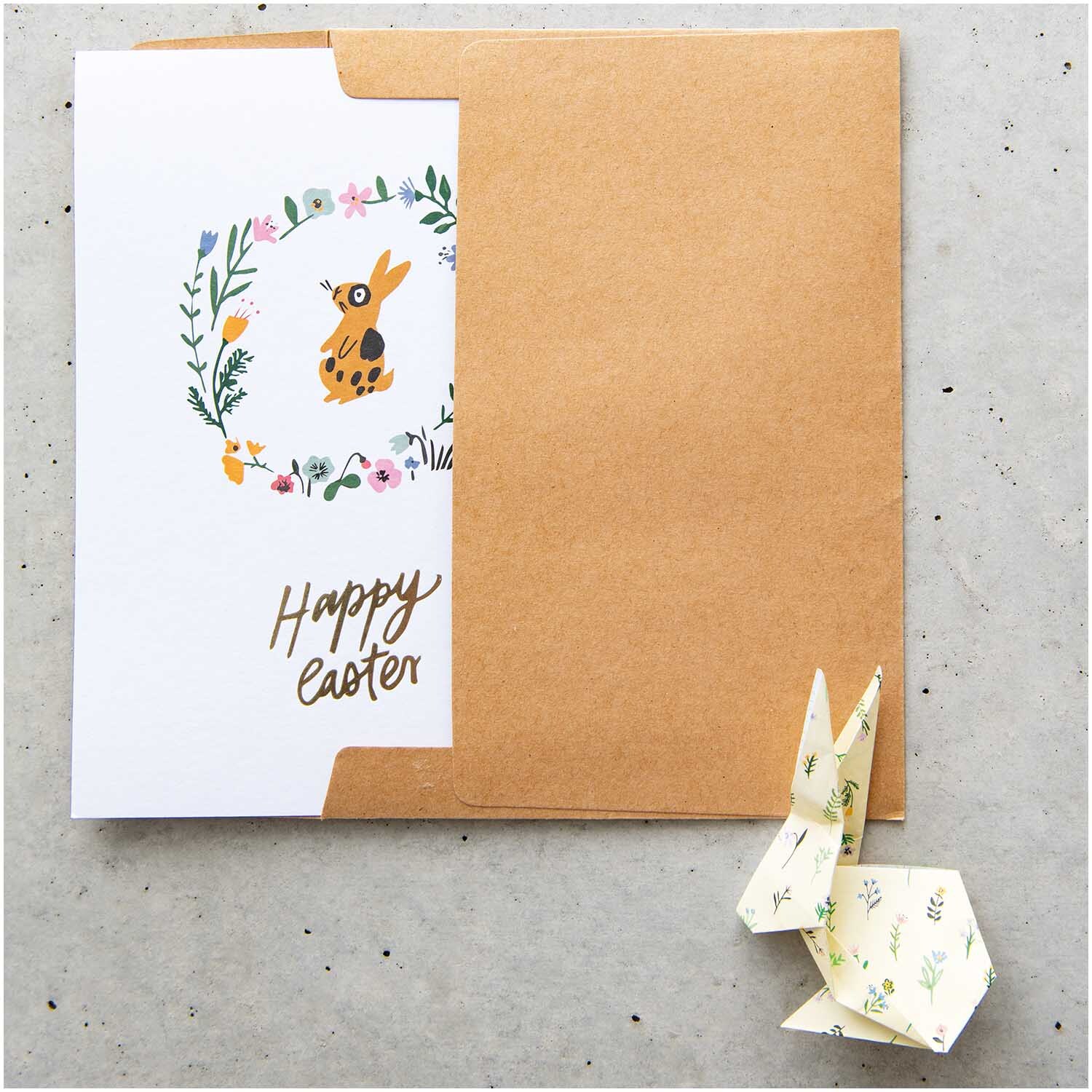 Paper Poetry Origami Bunny Hop 15x15cm 50 Blatt: Osterkarte mit braunem Umschlag und Origami-Hase, verziert mit floralen Motiven.