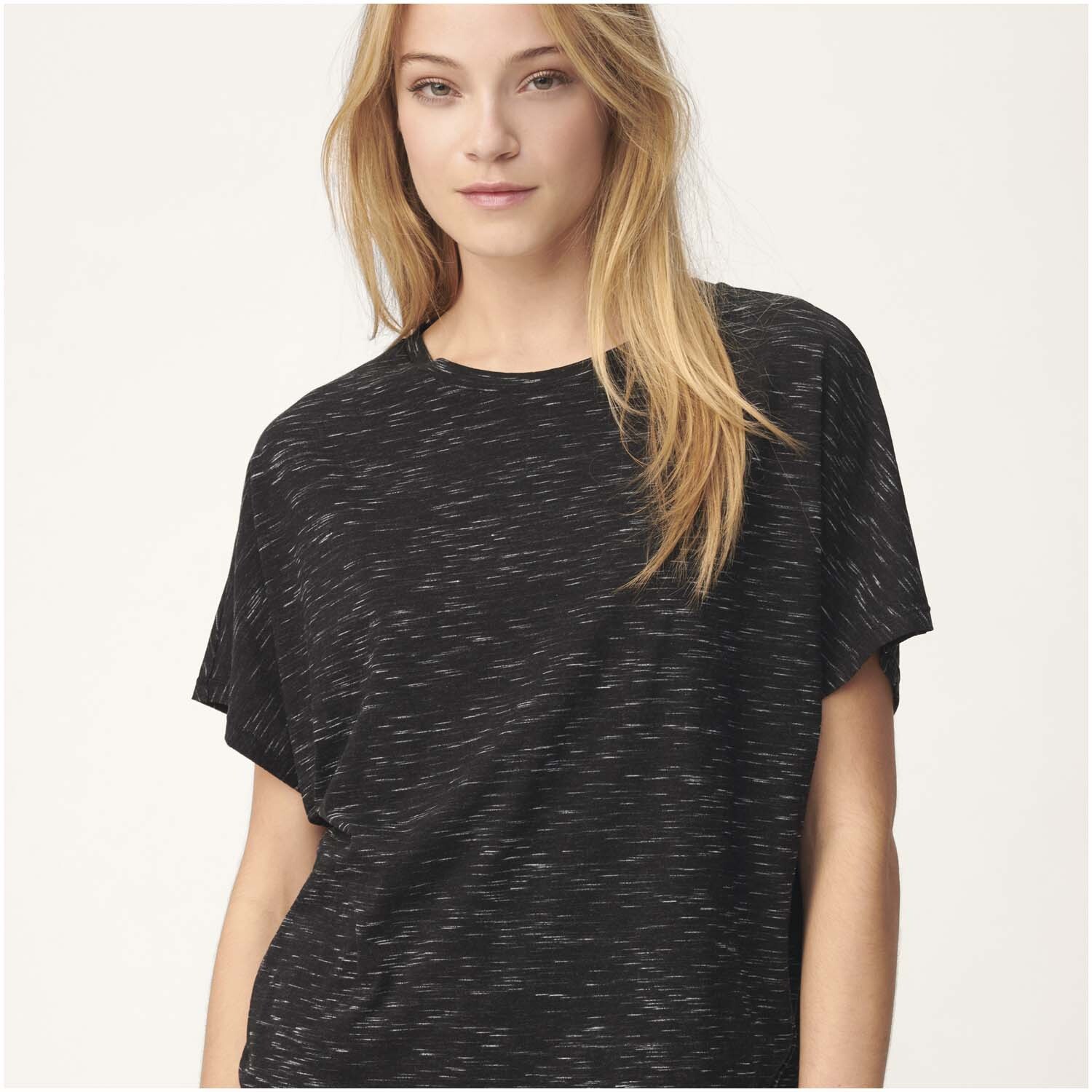 Meterware Jersey schwarz-weiß von Rico Design: Frau trägt ein schwarzes, gemustertes T-Shirt. Ideal für stilvolle, bequeme Kleidung.