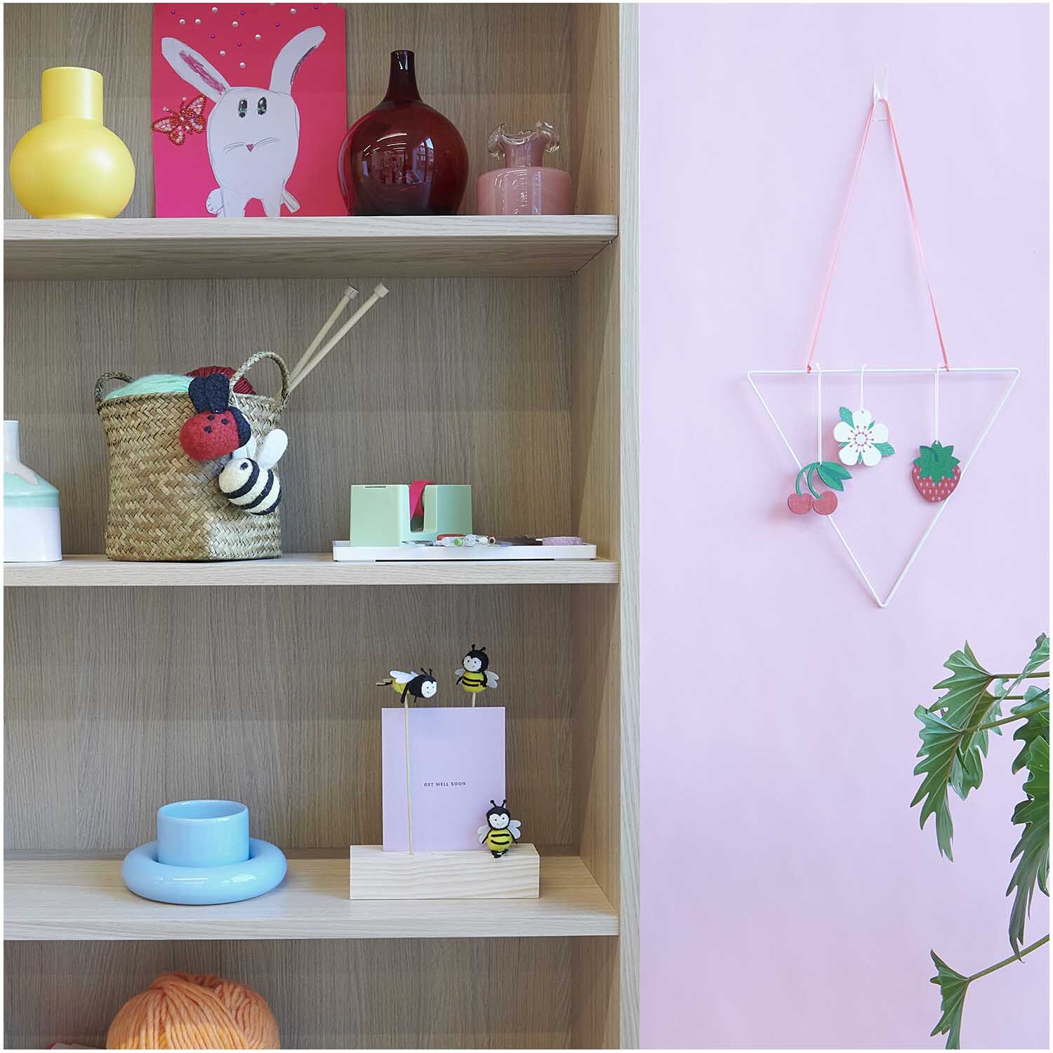 Filz-Marienkäfer zum Hängen 6,5x6,5cm an einer rosa Wand, dekoriert mit bunten Accessoires.