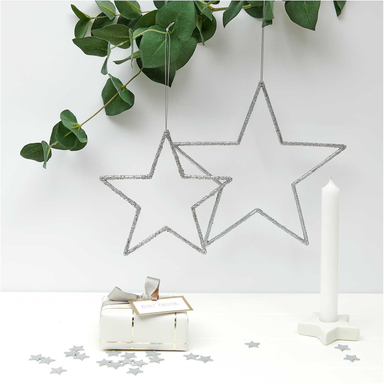 Hänger Stern mit Glitter silber von Rico Design, dekorativ an Zweigen hängend, neben Kerze.
