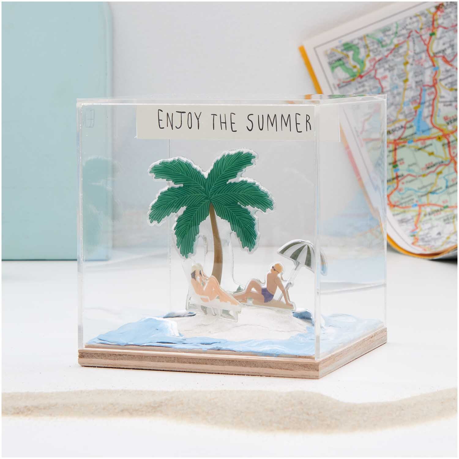 Figurico Modelliermasse 28g: Miniatur-Strandszene mit Palme und Liegestühlen in einem Glaswürfel.