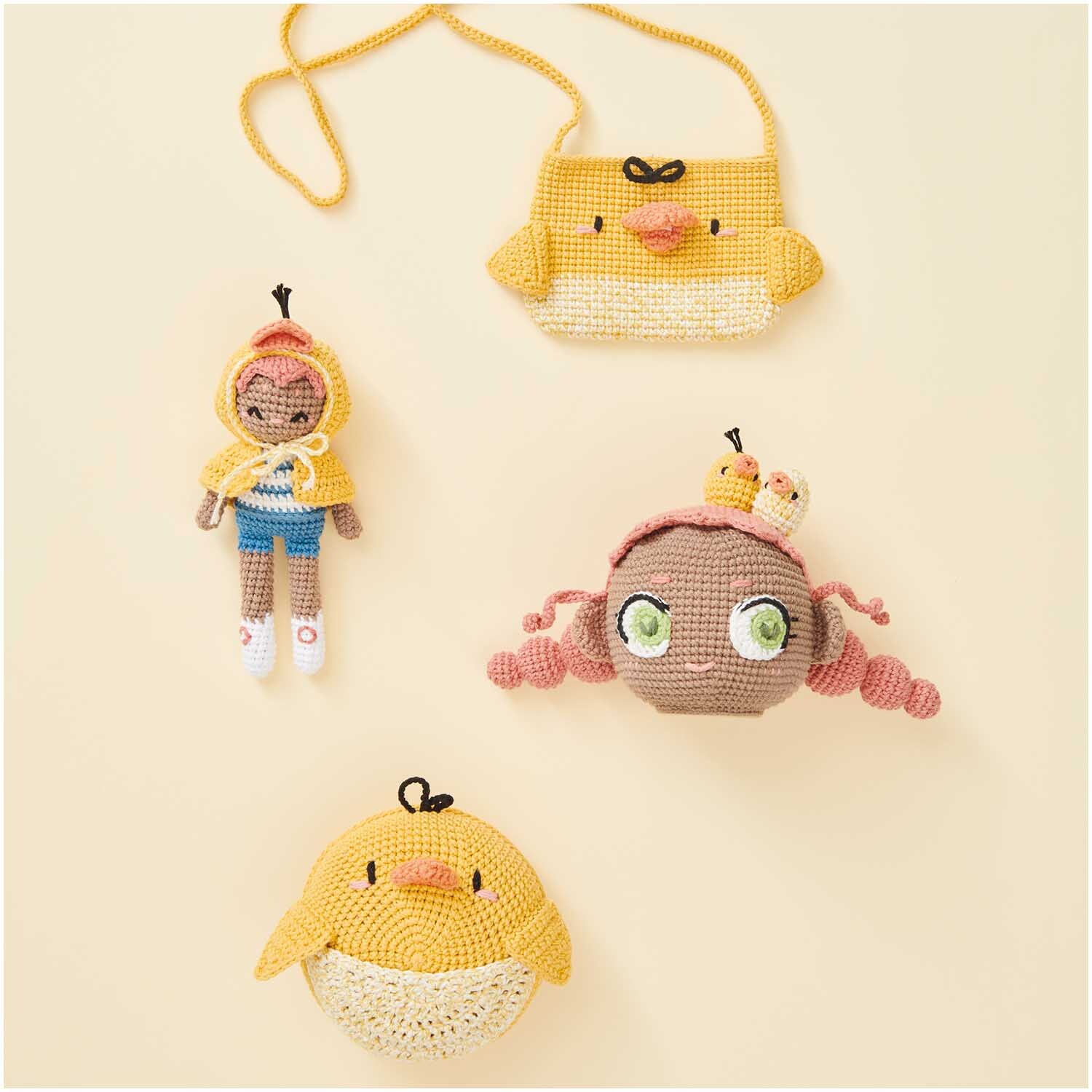 Creative Ricorumi Spray dk: Gelbe, gehäkelte Figuren und Accessoires von Rico Design, darunter Tasche und Puppen.
