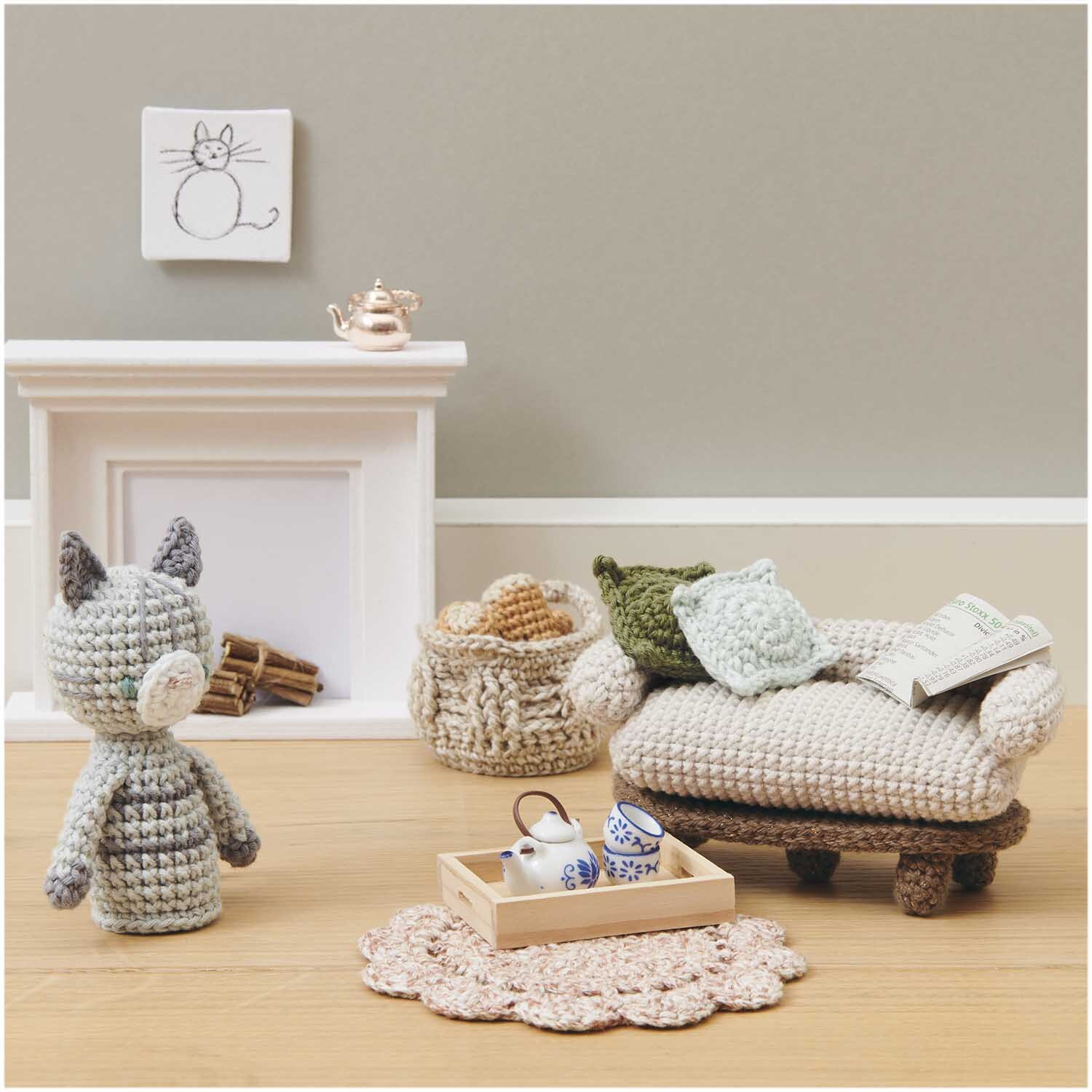 Miniatur Holztablett mit Teeservice auf gehäkeltem Teppich, neben Sofa und Kamin in Puppenhaus.