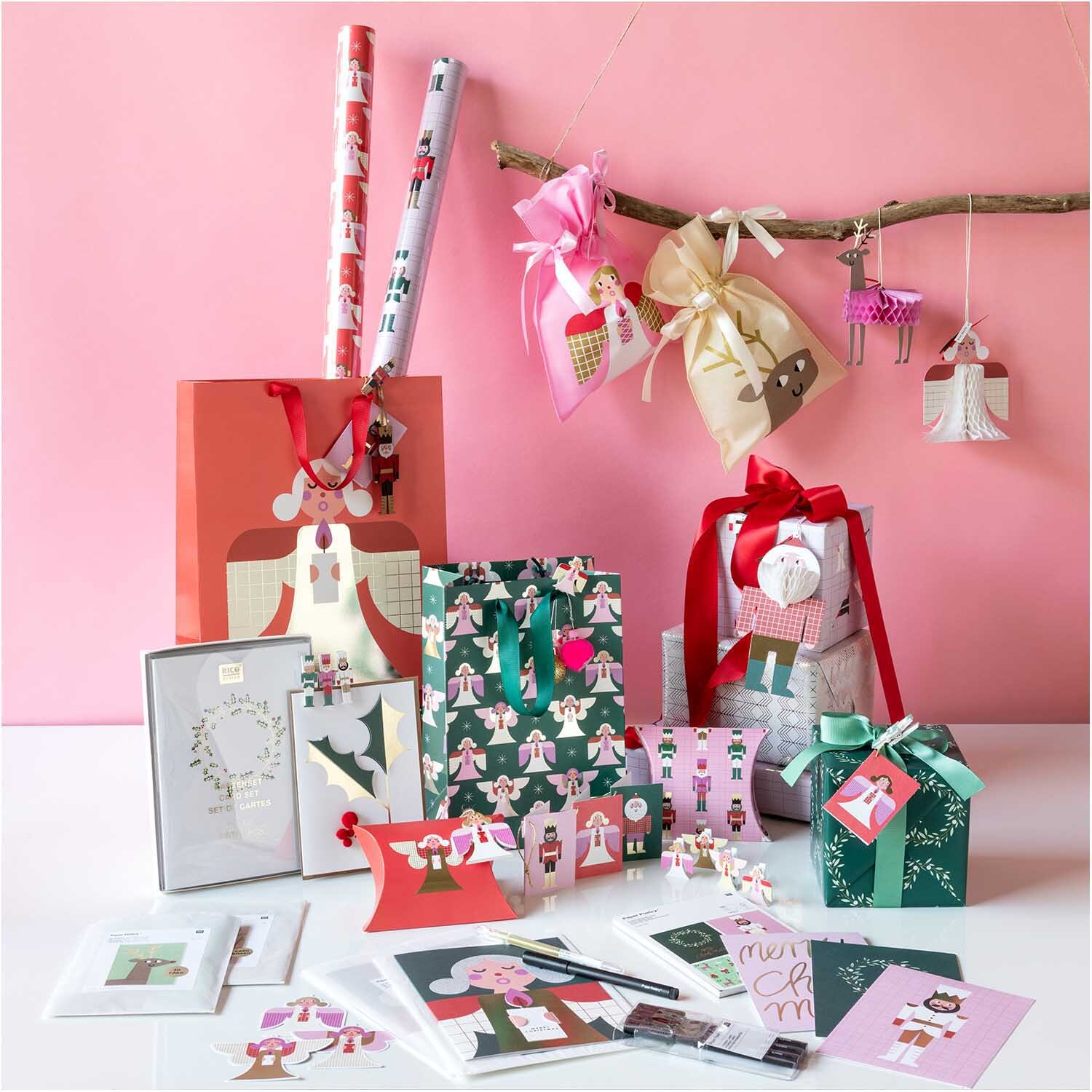 Paper Poetry Geschenktüte Engel klein rosa 20x30cm, umgeben von festlichen Geschenkverpackungen und Dekorationen. Ideal für kreative Geschenkideen.