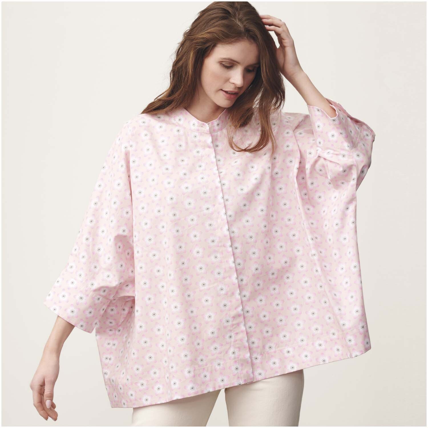 Meterware Baumwoll-Popelin rosa Kirschblüten: Frau trägt weite, rosa Bluse mit Kirschblütenmuster von Rico Design.