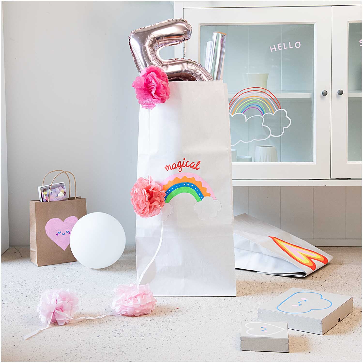 Kreidestifte Flüssigkreide Set Regenbogen 3mm 8 Farben von Rico Design, dekoriert mit bunten Ballons und Regenbogenmotiv in einem hellen Raum.