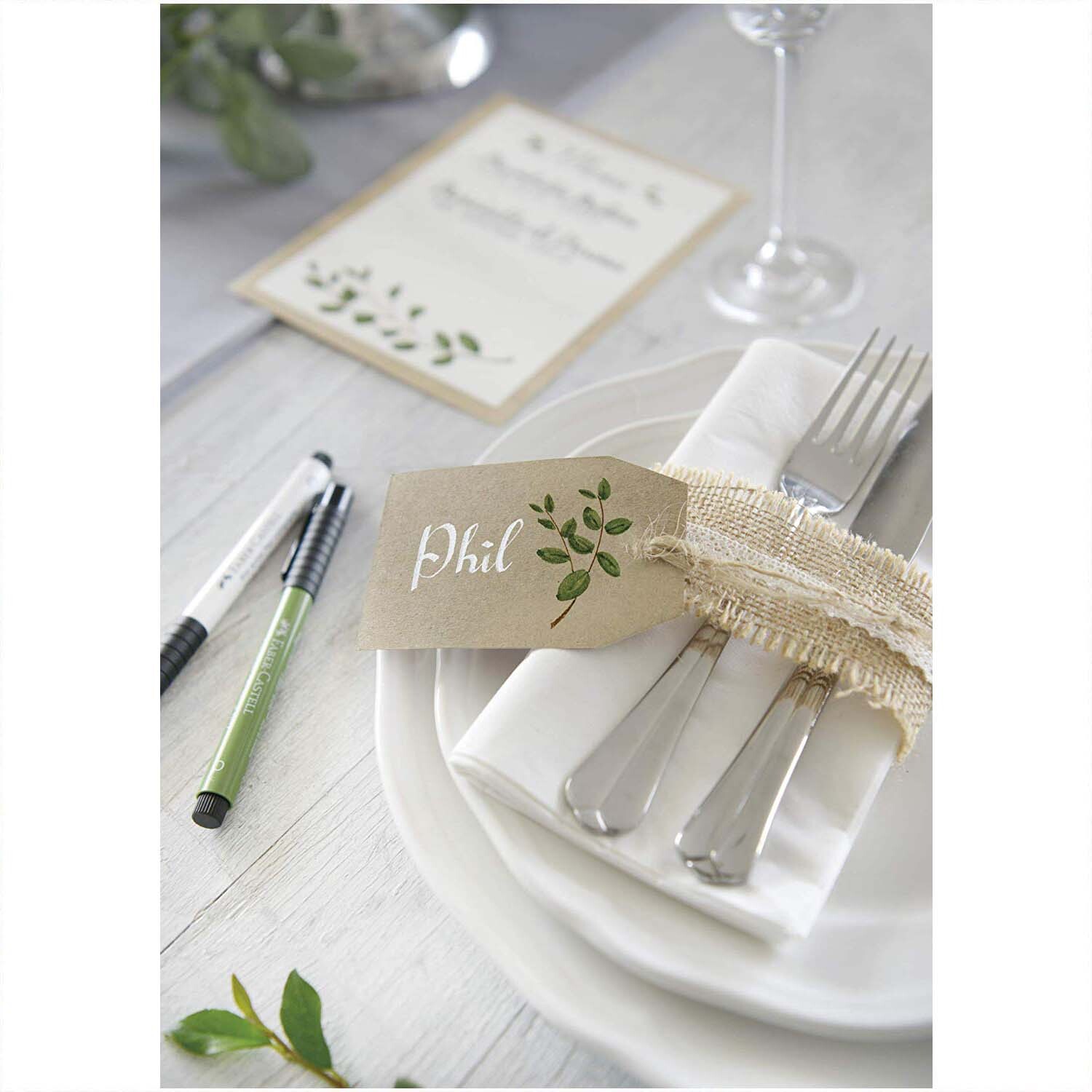 Tuschestift Pitt Artist Pen Calligraphy 8 Stück neben elegant gedecktem Tisch mit Besteck und Namenskarte. Ideal für kreative Kalligrafie-Projekte.