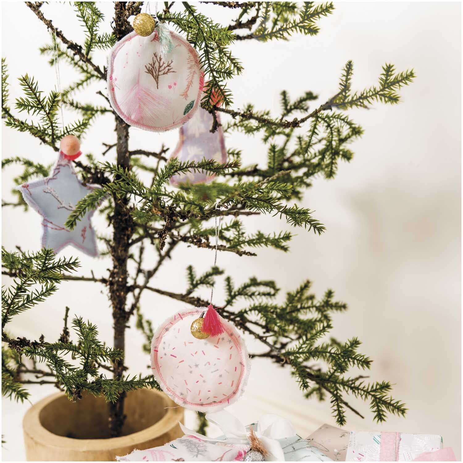 Musselin-Druckstoff Nostalgic Christmas Kränze zeigt zarte Weihnachtsdekoration an einem Baum.