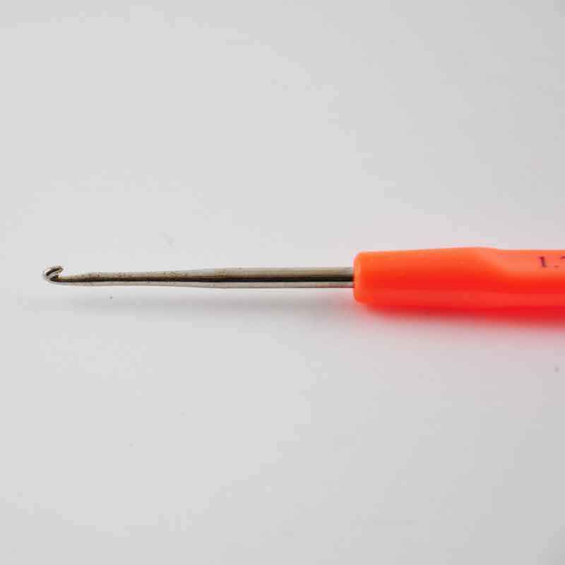 Häkelnadel 15cm von Rico Design mit ergonomischem Griff in leuchtendem Orange auf grauem Hintergrund.