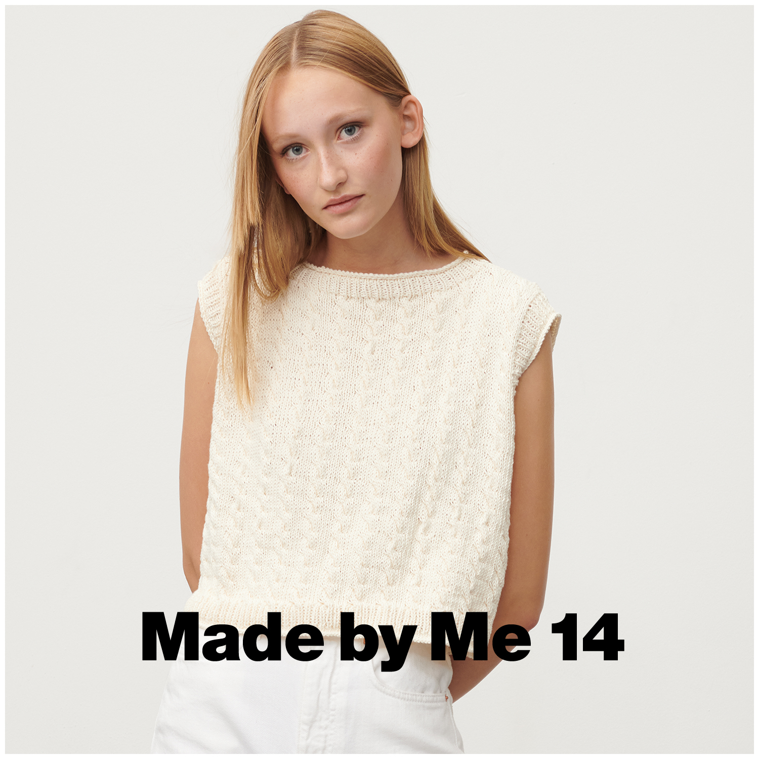 Essentials Organic Cotton dk: Frau trägt cremefarbenes Stricktop von Rico Design, lässig und stilvoll.