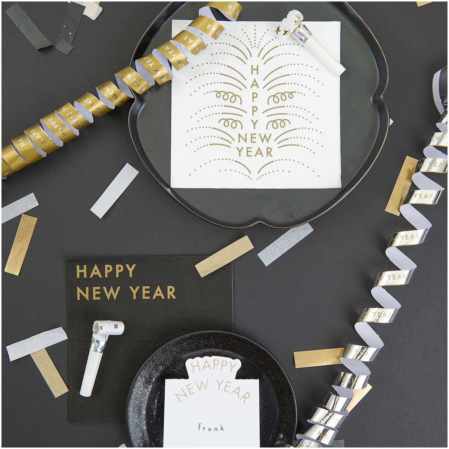 Servietten Happy New Year schwarz 33x33cm 20 Stück, dekoriert mit Partyartikeln und Konfetti auf einem Tisch. Ideal für festliche Anlässe.