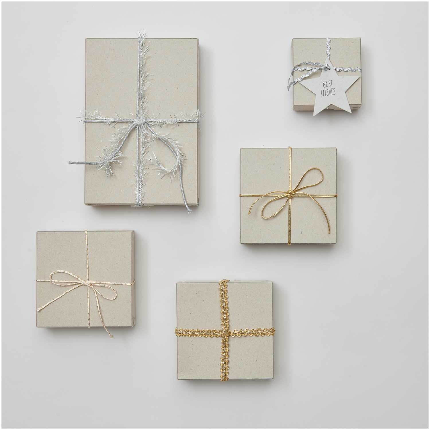 Ribbon Set Lucky Dip 30teilig: Fünf Geschenke mit gold-silbernen Bändern dekoriert auf grauem Hintergrund.
