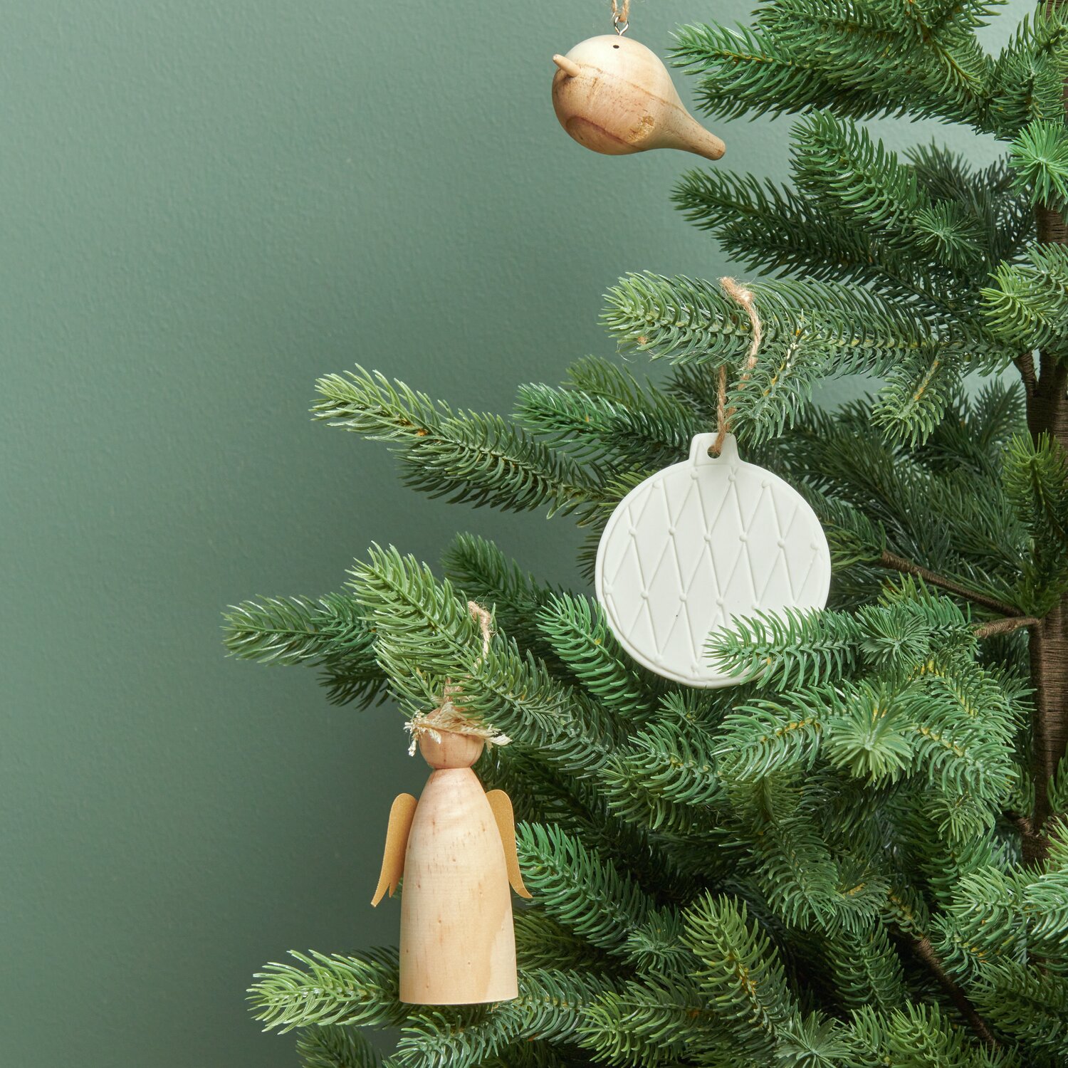 Holzhänger Vogel, Holzengel mit Krone und Porzellanhänger Kugel Weiß von Rico Design an einem Tannenbaum.