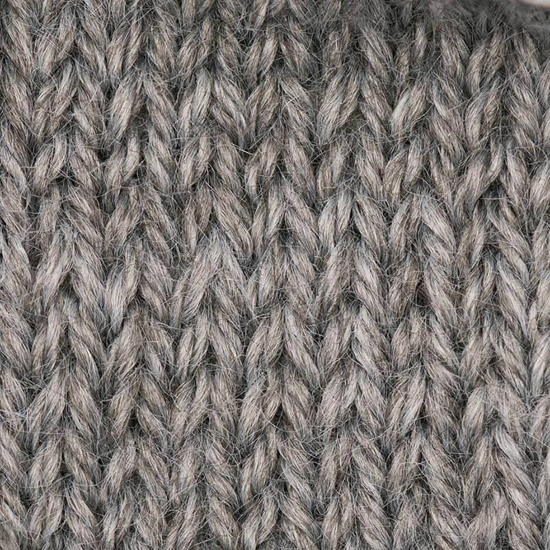 Essentials Merino Plus dk von Rico Design: Nahaufnahme von gestricktem Garn in Hellgrau, ideal für warme Strickprojekte.