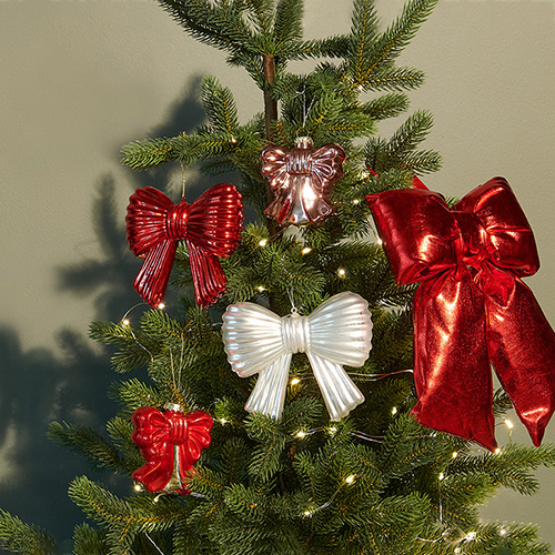 Ein Tannenbaum mit fünf verschiedenen Schleifenanhängern in rot und weiß.