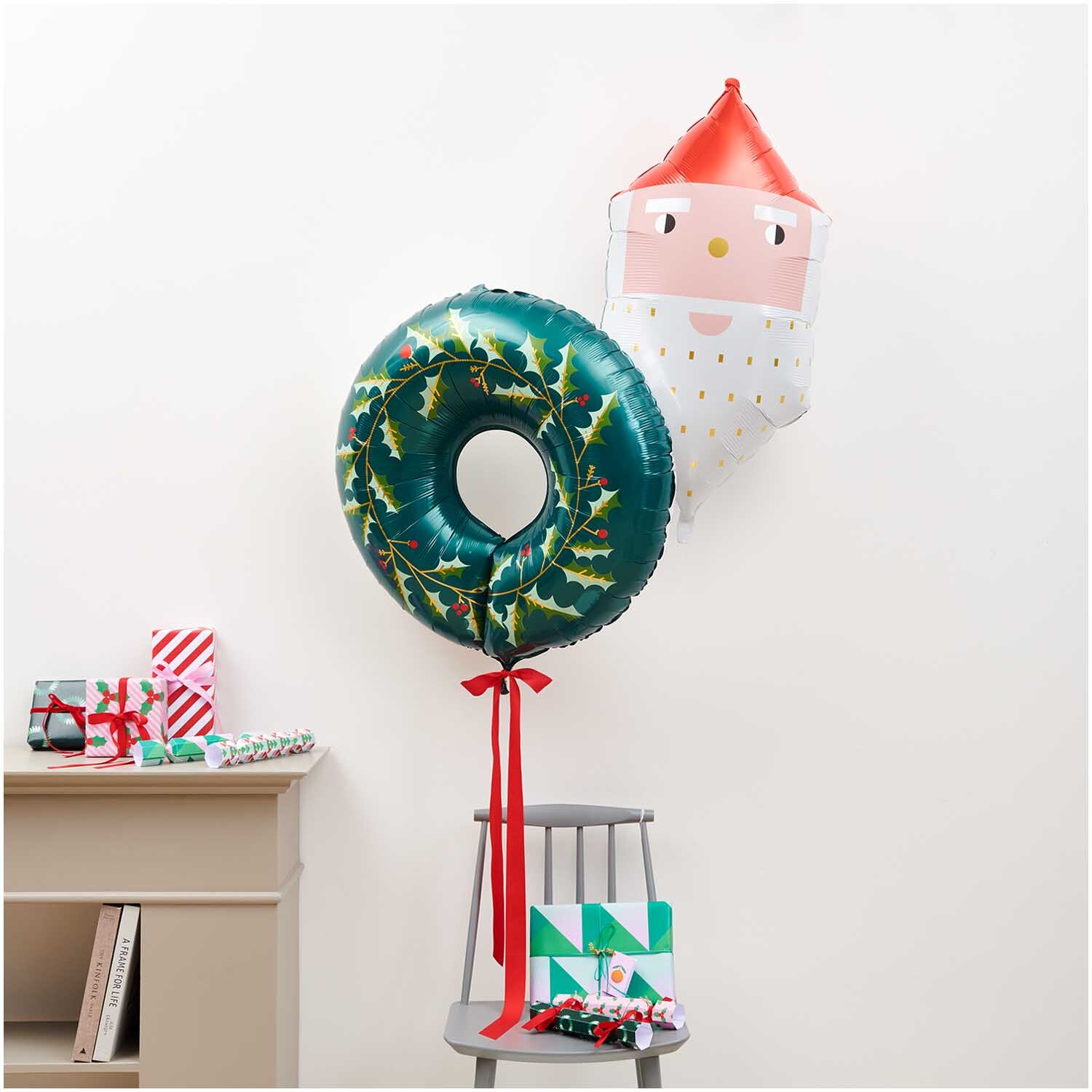 Folienballon Weihnachten Kranz von Rico Design: Ein grüner Kranzballon mit weihnachtlichem Motiv neben einem Weihnachtsmann-Ballon.