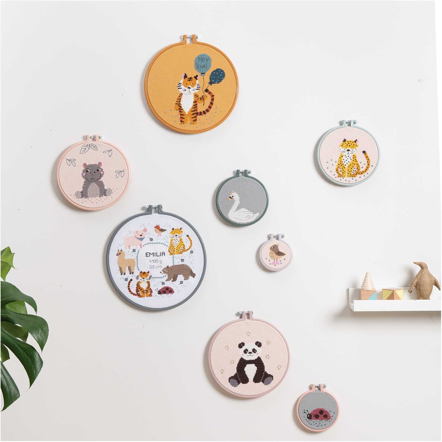 Stickring aus Kunststoff mintgrün 15,2cm: Verschiedene Stickringe mit Tiermotiven an einer weißen Wand. Ideal für kreative Dekoration.