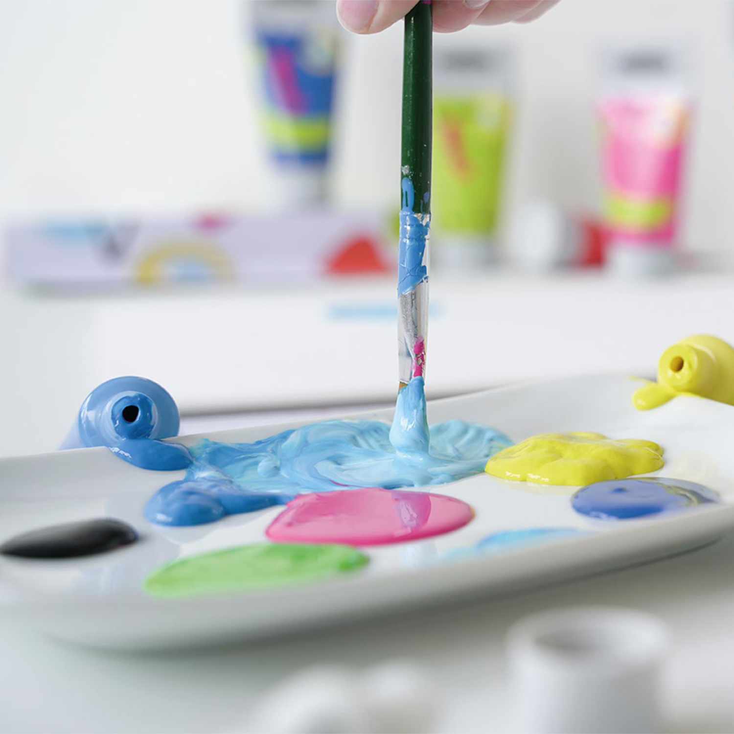 Kids Art Kinder-Künstlerfarbe: Ein Pinsel mischt leuchtende Farben auf einer Palette, ideal für kreative Kinderprojekte.