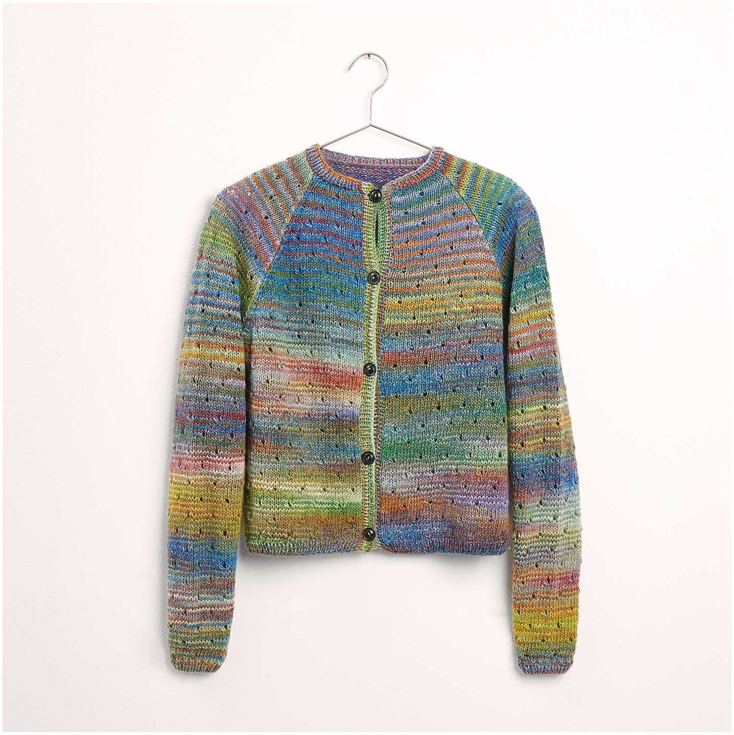 Strickset Jacke Modell 26 aus Die Neue Masche Nr. 7, bunte Strickjacke mit Knöpfen, hängend an einem Kleiderbügel.