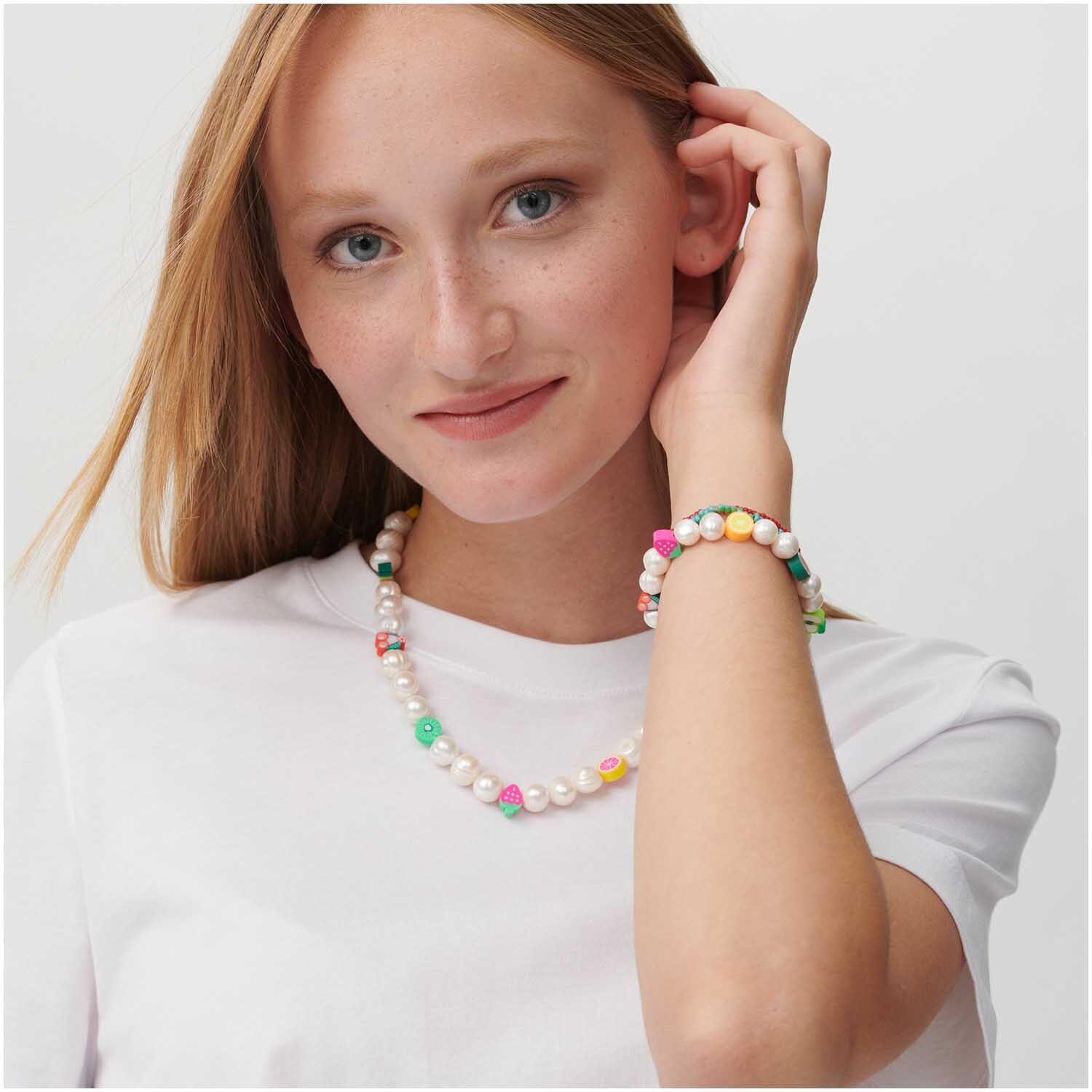 itoshii Tutti Frutti Perlen 11mm, getragen von einer Frau. Die Perlen sind mehrfarbig und von Rico Design.