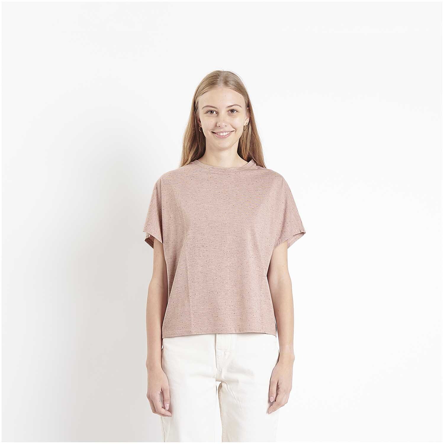 Stoffabschnitt Jersey Flocken Puder: Frau trägt ein puderfarbenes T-Shirt, lächelnd vor weißem Hintergrund. Größe 80x100cm.